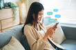 © Monster Ztudio - Young asian woman using mobile smartphone. Chatting conversation in chat box icons pop up bubble speech. Social media direct message