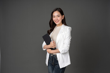 asian female executive with long hair standing hugging a tablet for work, holding a pen, with a beau