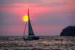 A lone sailboat against a sunset in the pacific ocean off the coast of Costa Rica.