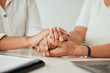 © K.A./peopleimages.com - Support, closeup with people holding hands and sitting at their home for counseling or therapy. Consulting or empathy, love or care and women hold hand together for compassion or help at their house