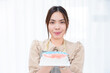 © kunchainub - happy asian woman chef hold homemade delicious sweet dessert cake on hand, cook and bake from bakery flour dough with cream during holiday