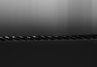 Black nylon rope in horizontal direction. Isolated on blurred black background. Close-up. Copy space.