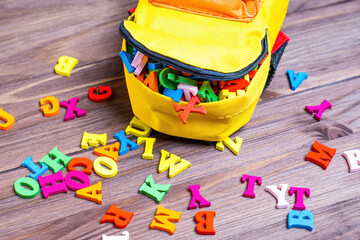 Tiny Backpack and Wooden Letters on a Wooden Table