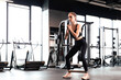 © ty - Muscular and strong girl doing exercises use fitness rubber at gym.