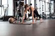 © ty - Portrait of a muscular woman on a plank position at gym.
