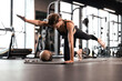 © ty - Portrait of a muscular woman on a plank position at gym.