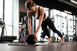 © ty - Fit and muscular woman exercising with medicine ball at gym.