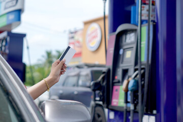 A woman using a credit card at a gas station