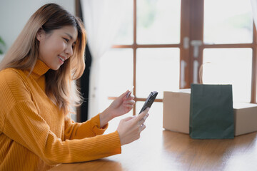 Wall Mural - Happy asian woman using laptop and credit card for online payment, E-commerce