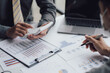 © Kritdanai - Business people talking about business strategy Collaborate teamwork during discussions on financial and marketing documents, financial data analysis meetings, and in-office charts.