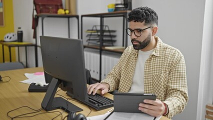 Sticker - Young hispanic man business worker using computer and touchpad working at office