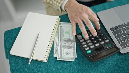 Sticker - Young hispanic man counting dollars using calculator writing notes at dinning room