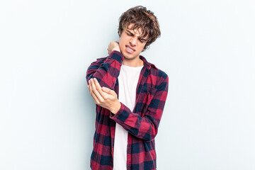 Wall Mural - Young caucasian man isolated on blue background massaging elbow, suffering after a bad movement.