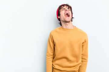 Wall Mural - Young caucasian man isolated on blue background shouting very angry, rage concept, frustrated.