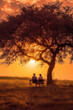 Älteres Paar mit weißen Haaren, Händchen haltend, sitzt auf einer Bank unter einem großen Baum auf einer Wiese im Nachglühen der untergehenden Sonne