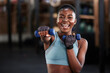 © Michael Cunningham/peopleimages.com - Portrait of boxer, dumbbell or happy black woman training, exercise or workout for a strong punch or power. Smile, face or African girl boxing with dumbbells, weights or exercising in fitness gym