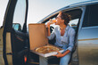 © Soloviova Liudmyla - Midle-aged woman eating just cooked italian pizza sitting on driver car seat during meal break and enjoying sunset light. Auto traveling, fast food eating or car jorney lunch break concept image.