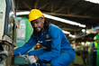 © KANGWANS - Africa American worker heavy industry worker engineer wearing safety suit Work in the background of an industrial factory.