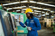 © KANGWANS - Africa American worker heavy industry worker engineer wearing safety suit Work in the background of an industrial factory.