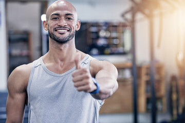 Thank you, portrait of man and with thumbs up at the gym with a lens flare. Success or motivation, agreement or health wellness and male athlete happy for support workout or fitness training