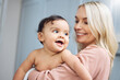 © Kay Abrahams/peopleimages.com - Love, smile and mother holding with her baby in the nursery room of their modern family home. Happy, bonding and young woman hugging her cute girl infant child with care and affection in their house.