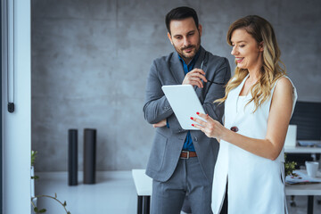 Shot of two young colleagues having a discussion in modern office. Confident young business people working together in the office. 