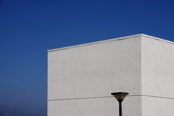 Wall Mural - Top of a white windowless building under blue sky