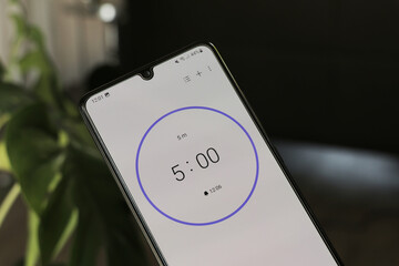 a phone with a black and white 5-minute timer to study with the pomodoro method on a blurry backgrou