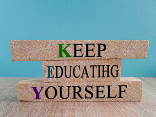 Keep educating yourself symbol. Brick blocks with words 'KEY, keep educating yourself'. Beautiful blue background, copy space. Business, educational and KEY, keep educating yourself concept.