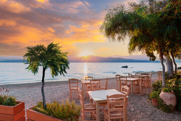 Wall Mural - Beautiful sunrise scene on the beach with a terrace and tropical trees illuminated by the sunlight in Nikiana, Lefkada, Greece