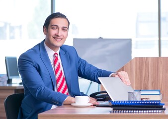 Wall Mural - Young handsome businessman sitting in the office