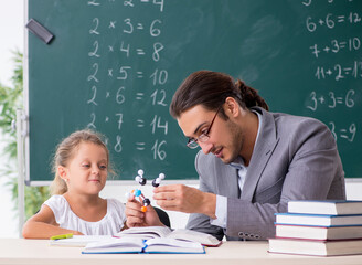 Teacher with young girl in the classroom