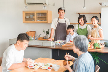 Poster - 家のダイニングで祖父母に料理を作る孫・親子（二世帯住宅）
