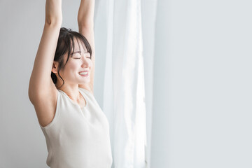 Poster - 寝起き・起床時にカーテンの前で朝日を浴びる女性（脱毛・脇）
