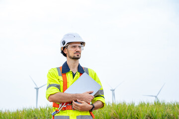 Poster - Engineer man looking and checking wind turbines at field,Wind turbine farm generator by alternative green energy.