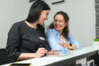 © Taras Grebinets - Smiling happy female patient talking to her doctor dentist hygienist, standing at the reception counter, discussing the treatment needs to perform in dentistry clinic. People. Healthcare. Medicine