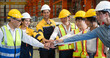 © chadchai - Group of male and female factory labor join hands together after finish meeting. Everyone wearing safety uniform and helmet. Workers working in the metal sheet factory.