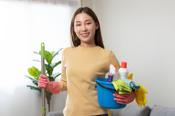 Wall Mural - Household clean up, asian woman worker holding bucket and mop when cleaning is done at home. Maid, housekeeper cleaner organizing messy dirty and untidy to tidy, housekeeping housework or chores.