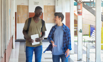 Wall Mural - African boy meeting in the school hallway with his caucasian teenager schoolmate