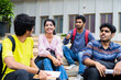 © WESTOCK - Group of happy students having chat with talking each other while sitting on college campus - concept of friendship, break time and communication