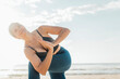 © Westend61 - Smiling woman practicing yoga with hands clasped at sunny day