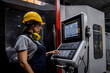 © Westend61 - Engineer wearing hardhat operating CNC machine keypad in modern factory