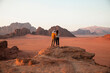 © Westend61 - Loving couple standing on rock at sunset in desert