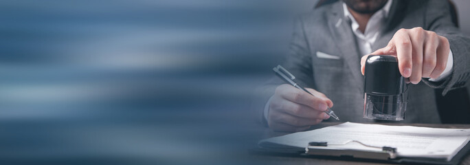 Businessman puts a stamp on the documents in the office.