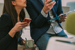 © qunica.com - Close up of co workers talking and looking at the phones