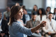 Presentation, training and coaching with a business woman talking to an audience during a workshop. Convention, speech and teaching with a female speaker giving a seminar to a group of employees