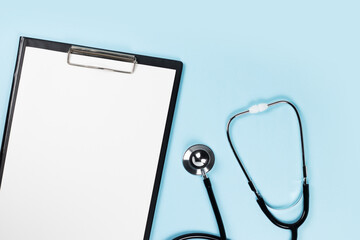 Blank clipboard with stethoscope on blue background
