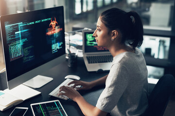 Typing, woman and hacker, computer programmer or coder hacking data. IT, focus and female developer, engineer or person programming, coding and writing software for phishing, cyber security or virus.