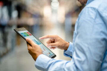 Close up, a businessman or supervisor uses a digital tablet to check the stock inventory, a Smart warehouse management system, supply chain and logistic network technology concept.