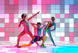 Disco aerobics. Young men in retro, colorful sportswear training against multicolored mosaic studio background. Concept of sportive and active lifestyle, humor, retro and vintage style. Ad